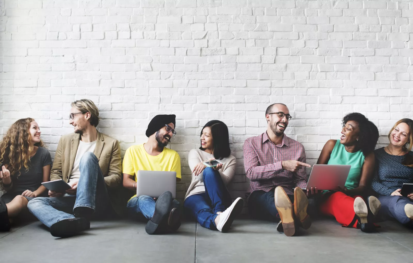 IT-Er community - people sitting down in front of a white wall